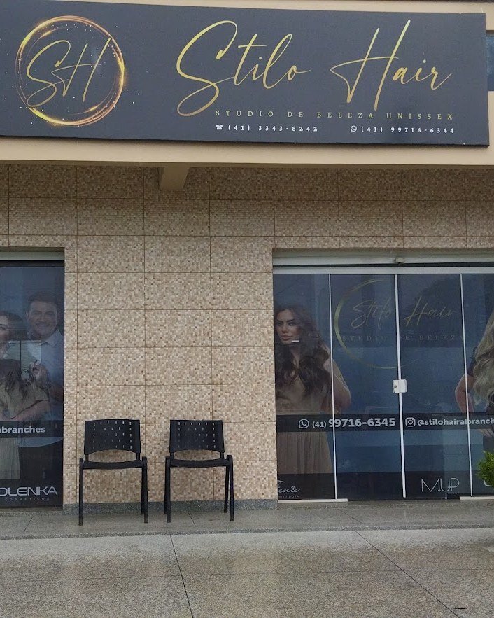 Fachada do Stilo Hair no Abranches, com a placa do studio de beleza unissex sobre a entrada